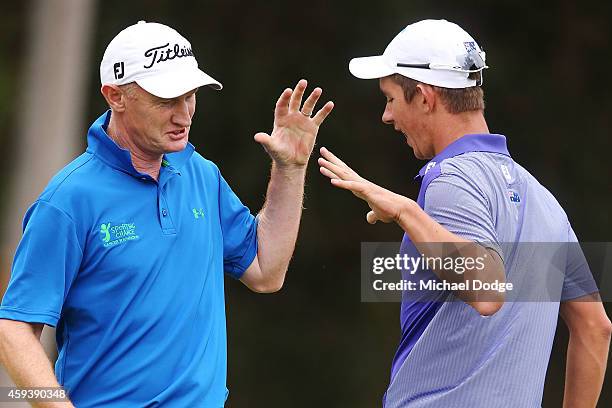 Richard Lee of New Zealand and Australian react together after both making birdies on the 16th green during day three of the Australian Masters at...