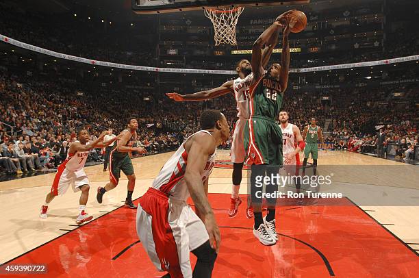 Amir Johnson of the Toronto Raptors blocks a shot by Khris Middleton of the Milwaukee Bucks during the game on November 21, 2014 at the Air Canada...