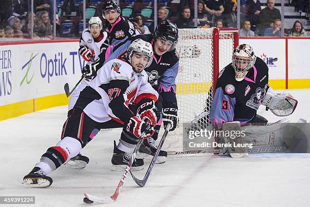 Loch Morrison of the Calgary Hitmen tries to check Torrin White of the Moose Jaw Warriors during a WHL game at Scotiabank Saddledome on November 21,...