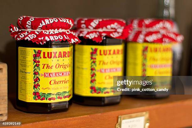 jars of luxardo italian maraschino cherries on a retail shelf - maraschino stock pictures, royalty-free photos & images