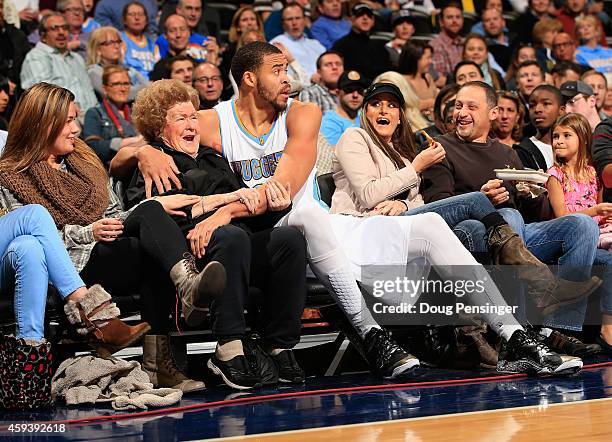 JaVale McGee of the Denver Nuggets protects the fans as he ended up in the front row after saving the ball against the New Orleans Pelicans at Pepsi...