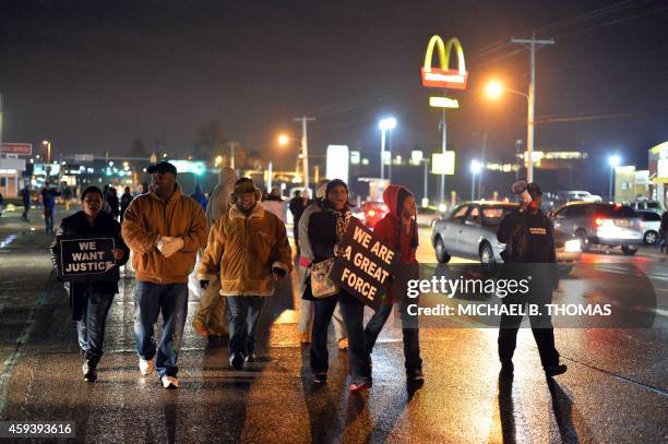 Demonstrators walk on a street shouting slogans to protest the shooting death of 18-year-old Michael Brown in Ferguson, Missouri, on November 21,...