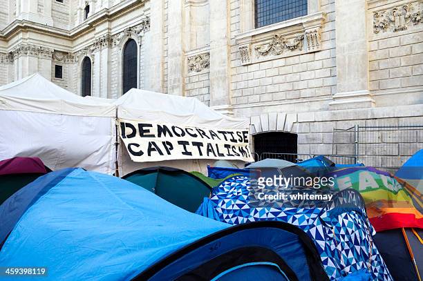 'democratise capitalism' banner on tent at 'occupy london' - capitalism stock pictures, royalty-free photos & images