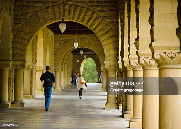 students walk along covered footpath at stanford university - palo alto stock pictures, royalty-free photos & images
