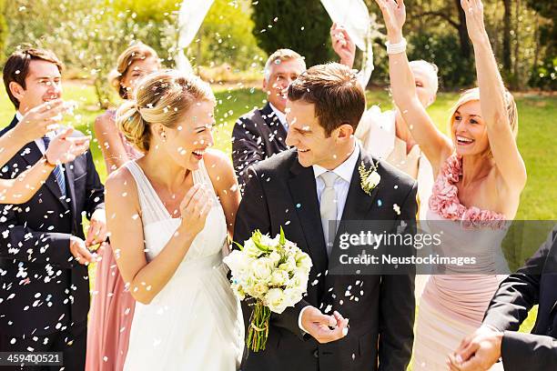 guests throwing confetti on couple during wedding reception - bridesmaid stock pictures, royalty-free photos & images