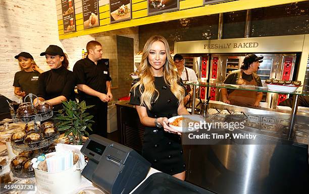 Lauren Pope from 'The Only Way Is Essex' helps serve behind the counter at the Spudulike opening at Lakeside Shopping Centre on November 22, 2014 in...