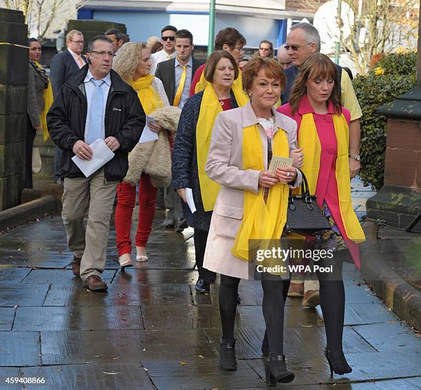 Family and friends wear yellow scarfs, ribbons or ties as they arrive for a memorial service for murdered British aid worker Alan Henning at Eccles...