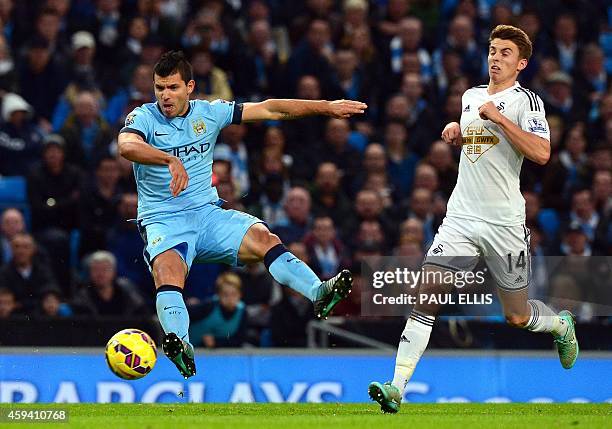 Manchester City's Argentinian striker Sergio Aguero shoots towards goal as Swansea City's English midfielder Tom Carroll tries to stop him during the...