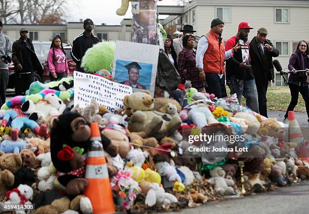 Michael Brown Sr., father of Michael Brown, delivers turkeys during an annual Thanksgiving basket give-away as he walks past a memorial for his son...