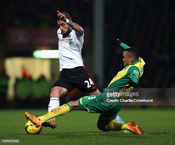 Ashkan Dejagah looks to get past Fulham's Martin Olsson during the Barclays Premier League match between Norwich City and Fulham at Carrow Road on...
