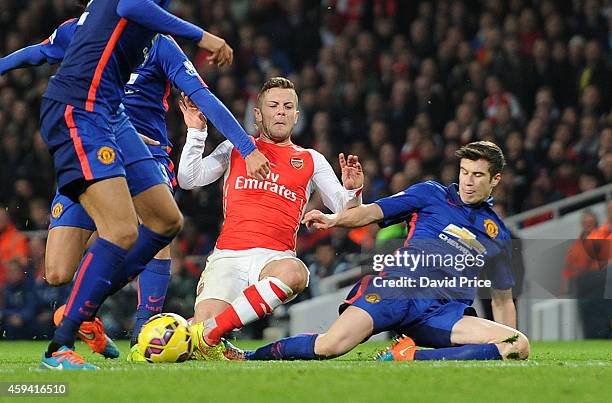 Jack Wilshere of Arsenal twists his ankle under a challenge from Paddy McNair of Manchester United during the match Arsenal v Manchester United in...