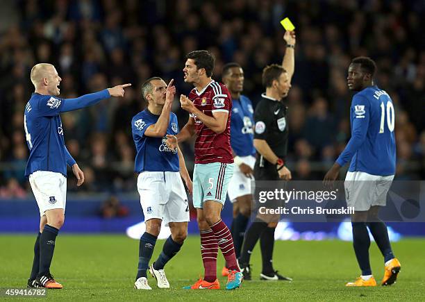 James Tomkins of West Ham United is challenged by Steven Naismith and Leon Osman of Everton after he clashed with team-mate Kevin Mirallas during the...