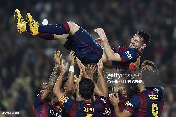 Barcelona's Argentinian forward Lionel Messi is thrown into the air by his teammates as they celebrate his new record after he scored during the...