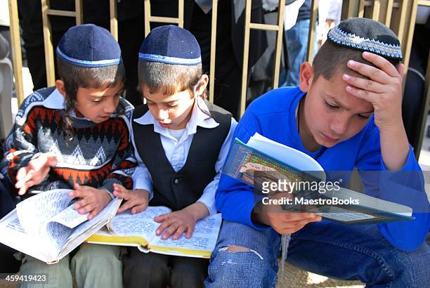 three children reading the bible. - yarmulke stock pictures, royalty-free photos & images