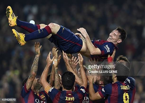 Barcelona's Argentinian forward Lionel Messi is thrown into the air by his teammates as they celebrate his new record after he scored during the...