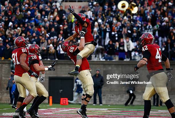 Andrew Fischer of the Harvard Crimson is lifted in the air by teammate Michael Mancinelli following Fischer's game-winning touchdown in the fourth...