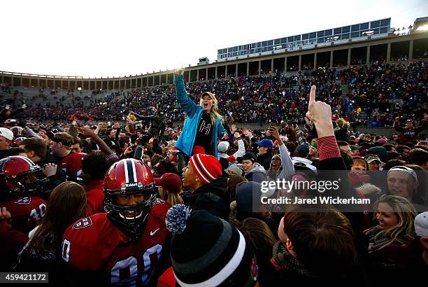 Harvard Crimson fans celebrate after rushing the field following their 31-24 win against the Yale Bulldogs at Harvard Stadium in their 131st meeting...