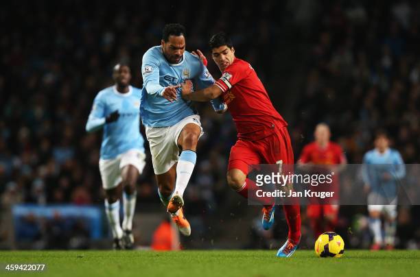 Luis Suarez of Liverpool challenges for the ball with Joleon Lescott of Manchester City during the Barclays Premier League match between Manchester...