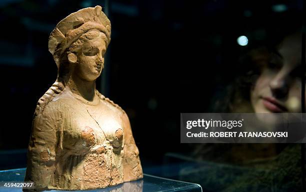 Woman looks at a second century BC terracotta bust presented during the annual archaeological exhibition at the Museum of the City of Skopje on...