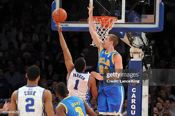 Travis Wear of the UCLA Bruins defends a shot against Jabari Parker of the Duke Blue Devils during the CARQUEST Auto Parts Classic at Madison Square...