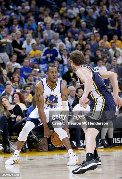 Golden State Warriors guard Andre Iguodala dribbles the ball while guarded by Utah Jazz forward Joe Ingles at ORACLE Arena on November 21, 2014 in...