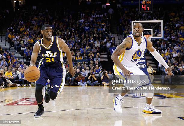 Utah Jazz guard Ian Clark drives toward the basket past Golden State Warriors guard Andre Iguodala at ORACLE Arena on November 21, 2014 in Oakland,...