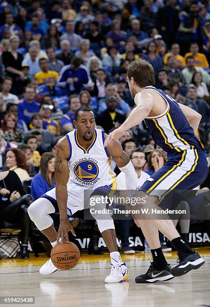 Golden State Warriors guard Andre Iguodala dribbles the ball while guarded by Utah Jazz forward Joe Ingles at ORACLE Arena on November 21, 2014 in...