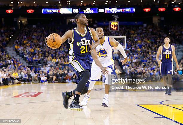 Utah Jazz guard Ian Clark drives toward the basket past Golden State Warriors guard Andre Iguodala at ORACLE Arena on November 21, 2014 in Oakland,...