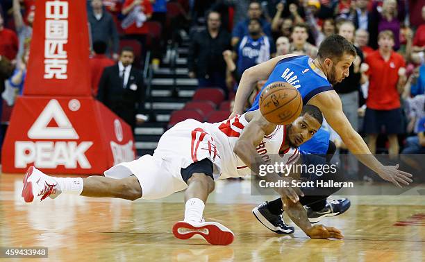 Trevor Ariza of the Houston Rockets and J.J. Barea of the Dallas Mavericks battle for a loose ball during their game at the Toyota Center on November...