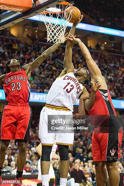 Louis Williams and Chuck Hayes of the Toronto Raptors fight Tristan Thompson of the Cleveland Cavaliers for a rebound during the first half at...