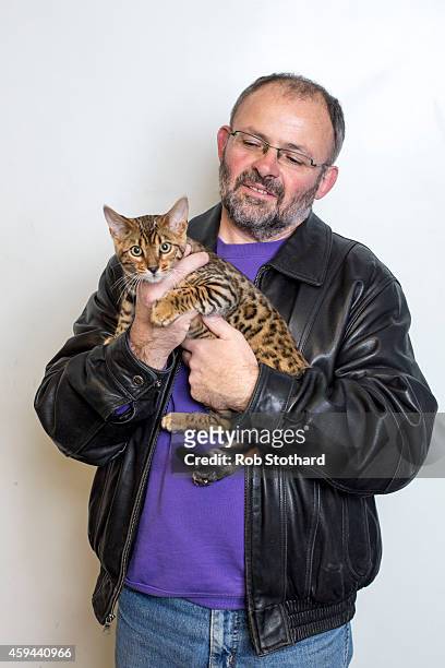 Mark Irwing poses for a portrait with a Brown Spotted Bengal cat called 'Shomili Ice-Anna' at the Governing Council of the Cat Fancy's 'Supreme...