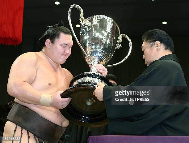 Mongolian-born "yokozuna", or grand champion, Hakuho receives the Emperor's Cup from president of the Japan Sumo Association Kitanoumi during the...