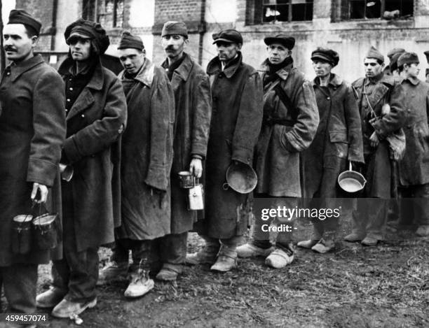 Photo taken on March 15, 1945 in a nazi concentration camp liberated by Allied troops shows deportees waiting in line to receive food. The prisoners...