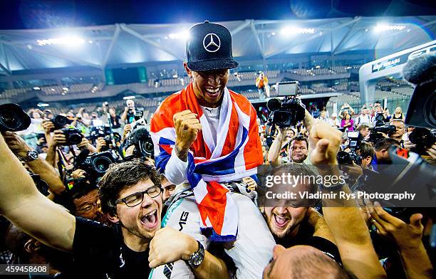 Lewis Hamilton of Great Britain and Mercedes GP Petronas is celebrated by his team after becoming World Champion following his win during the Abu...