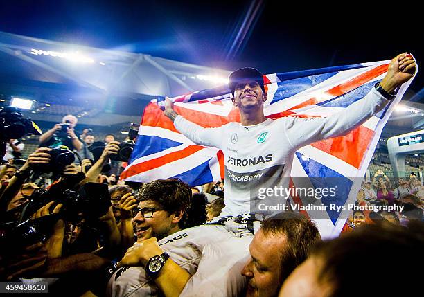 Lewis Hamilton of Great Britain and Mercedes GP Petronas is celebrated by his team after becoming World Champion following his win during the Abu...