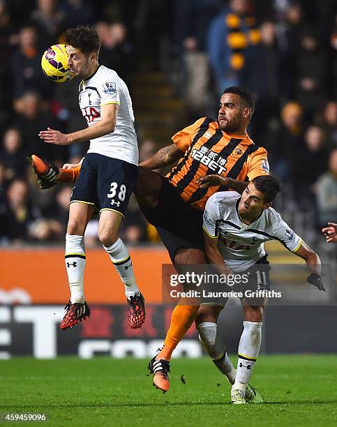 Tom Huddlestone of Hull City challenges Ryan Mason and Erik Lamela of Tottenham Hotspur during the Barclays Premier League match between Hull City...