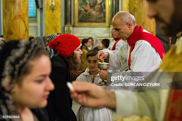 Priests give communion during a Sunday mass at St. Esprit Cathedral on November 23 at Sisli in Istanbul. Pope Francis will visit Turkey from November...