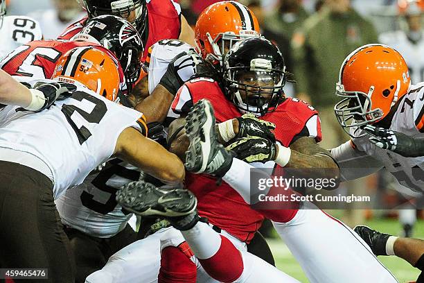 Steven Jackson of the Atlanta Falcons is tackled by a group of Cleveland Browns in the second half at Georgia Dome on November 23, 2014 in Atlanta,...