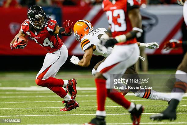 Roddy White of the Atlanta Falcons stiff arms Justin Gilbert of the Cleveland Browns in the second half at Georgia Dome on November 23, 2014 in...