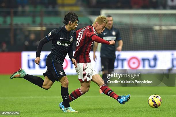 Keisuke Honda of AC Milan is challenged by Pires Ribeiro Dodo of FC Internazionale Milano during the Serie A match between AC Milan and FC...