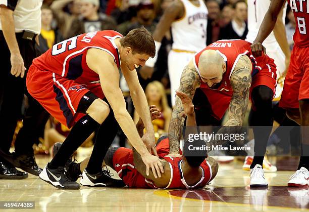 Jeff Teague of the Atlanta Hawks celebrates on the court with Kyle Korver and Pero Antic after scoring the game winning basket in double overtime...