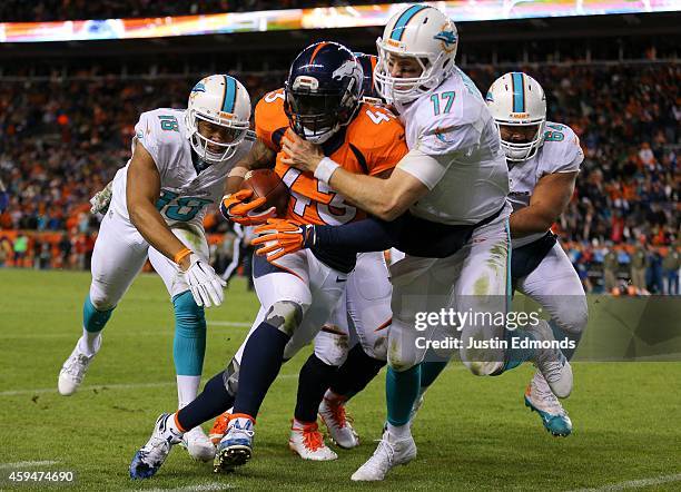 Strong safety T.J. Ward of the Denver Broncos is tackled out of bounds by quarterback Ryan Tannehill of the Miami Dolphins after a fourth quarter...