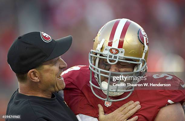 Head coach Jim Harbaugh of the San Francisco 49ers celebrates with Justin Smith after a forced fumble in the fourth quarter against the Washington...