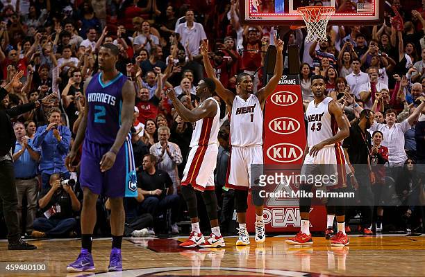 Chris Bosh, Luol Deng and Shawne Williams of the Miami Heat react to winning a game against the Charlotte Hornets at American Airlines Arena on...