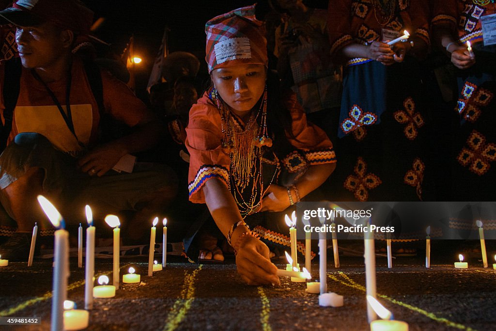 A young girl from a local tribe in Mindanao light up candles...