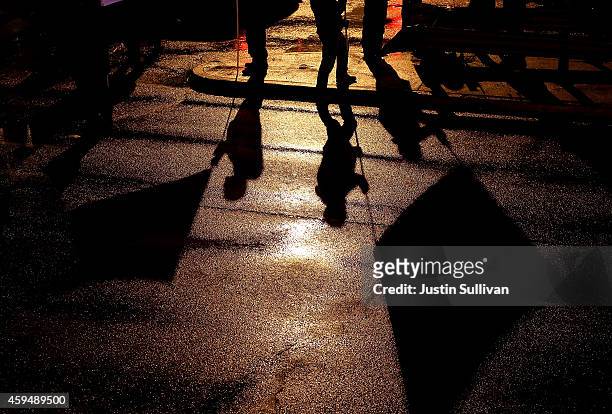 The shadows of demonstrators carrying banners are cast onto the street as they protest the shooting death of 18-year-old Michael Brown on November...