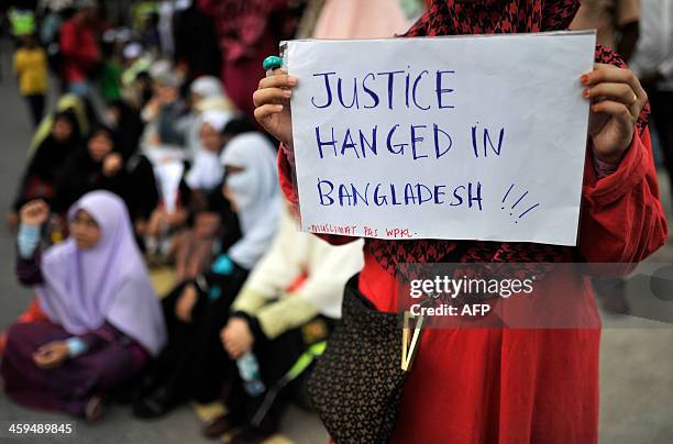 Malaysian Islamist holds a placard during a rally against the execution of top Bangladeshi Islamist leader Abdul Quader Molla in Kuala Lumpur on...