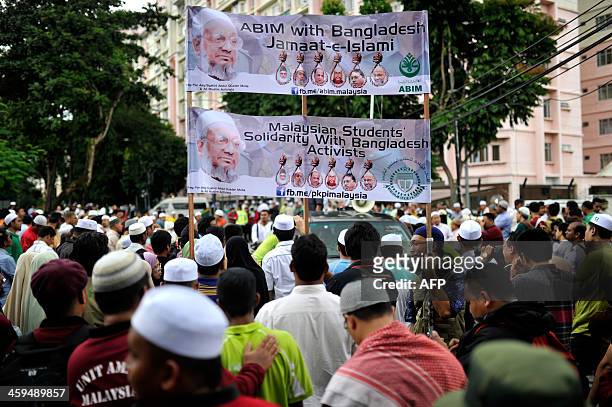 Malaysian Islamists hold up banners as they gather outside the Bangladesh embassy during a rally against the execution of top Bangladeshi Islamist...