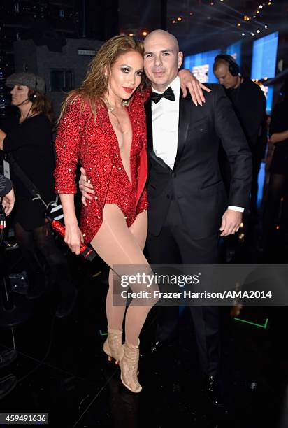 Recording artist Jennifer Lopez and host Pitbull pose backstage at the 2014 American Music Awards at Nokia Theatre L.A. Live on November 23, 2014 in...