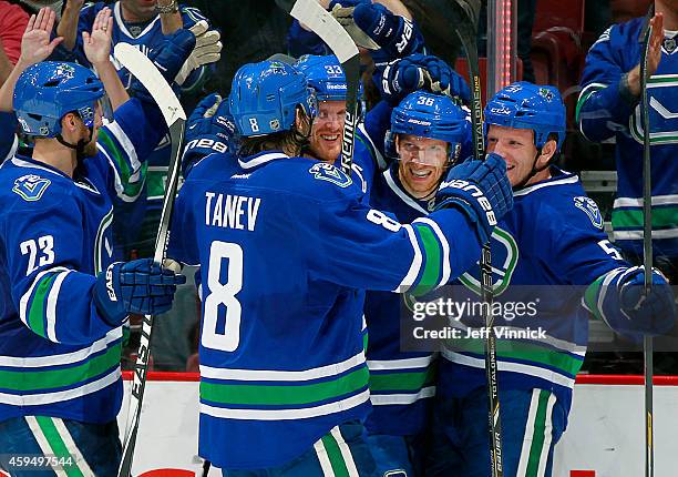 Alexander Edler, Christopher Tanev, Henrik Sedin and Luca Sbisa congratulate Jannik Hansen of the Vancouver Canucks after he scored against the...